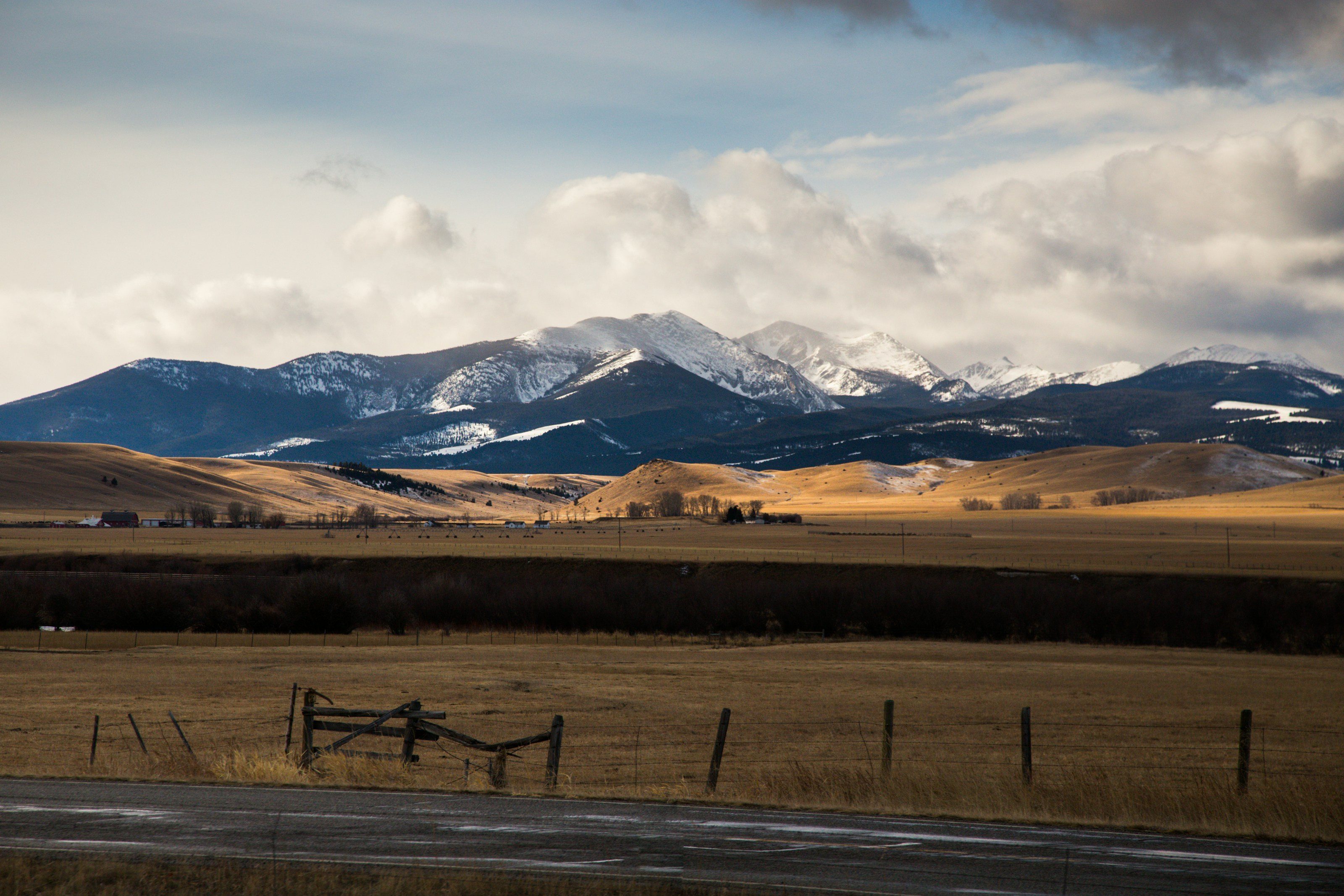 Snow-capped mountains above golden fields near Bozeman, Montana